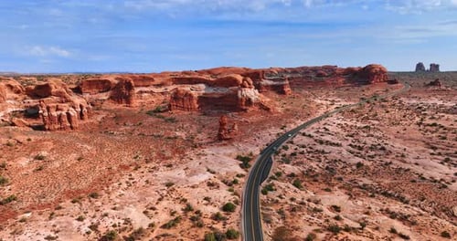 Following two cars moving by the highway in the desert.