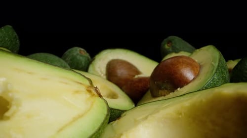 The camera moves forward through sliced avocado halves, getting closer and closer to the pit.