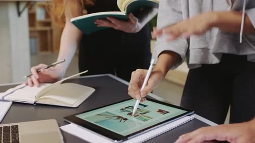 Professionals Collaborate Using Tablet and Notebooks in Workplace