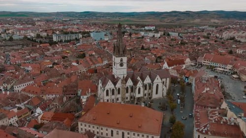 A historic european city with a large church in the center and surrounding rooftops, aerial view