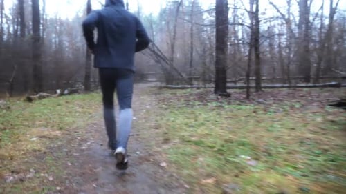 Young Sportsman Running Along Path at Woodland Sporty Runner Jogging Along Trail at Autumn Forest