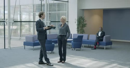 Business people in office meeting in lobby wearing protective face mask and using digital tablet