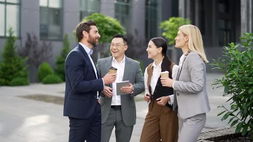 Diverse Colleagues Discuss Business Outside Office Building