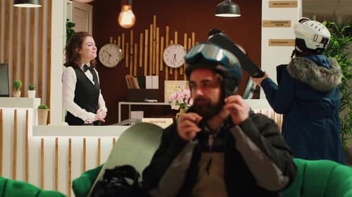 Hotel Receptionist Helping Skiing Guest at Lobby