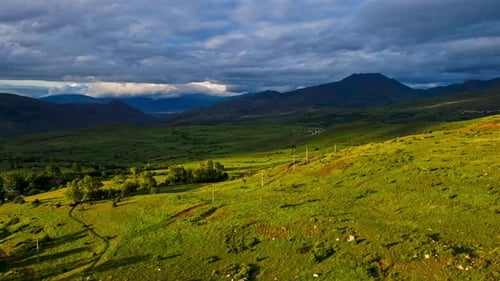 A large, grassy field with a cloudy sky in the background