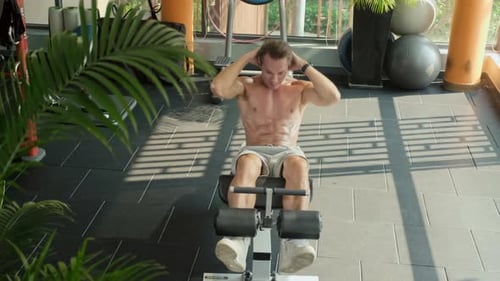 Shirtless Athlete Doing Abs Exercises in Gym