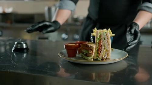 Professional kitchen in the hotel restaurant, the chef presses the bell the club sandwich is ready