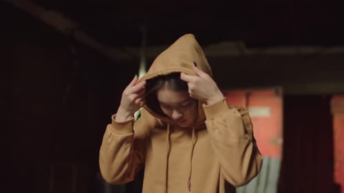Young Woman Puts Up Hood in Urban Setting