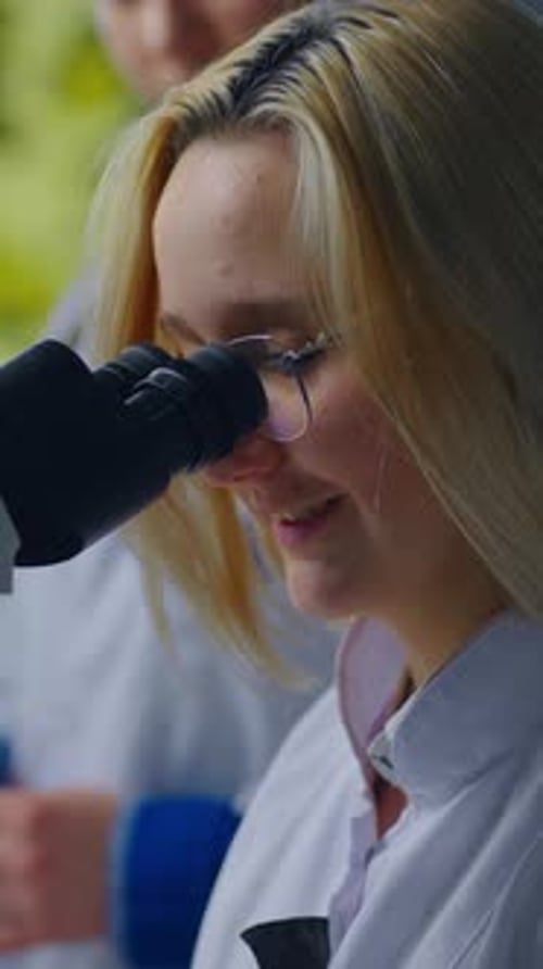 Young Women Using Microscope in a Laboratory Setting