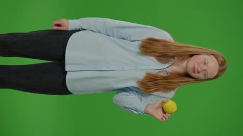 Split Green ScreenVertical Video Teenage Girl Smiles As She Eats An Apple Embodying Healthy Eating
