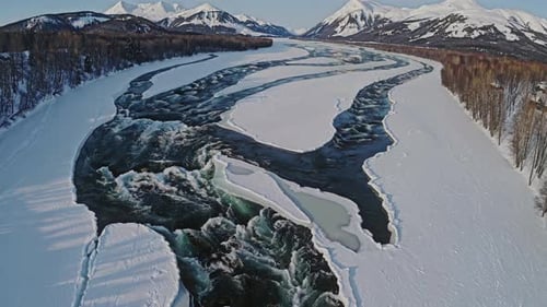 A Breathtaking Frozen River Landscape Featuring a Magnificent Mountain Background is Showcased