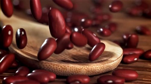 Kidney Beans Falling on Wooden Spoon Close Up