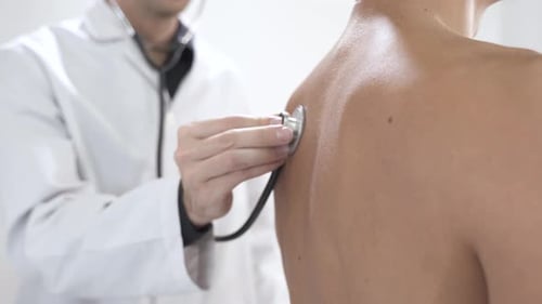Close Up View of Doctor Using Stethoscope While Examining Patient in Hospital