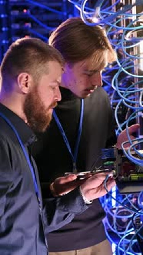 Men Working in Server Room with Tablet