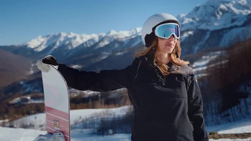 Female Snowboarder Posing on Mountain on Sunny Winter Day