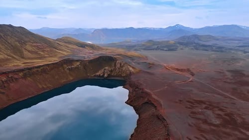 A lake locating in the crater of volcano. Barren deserted rocky land of Iceland. Aerial perspective.