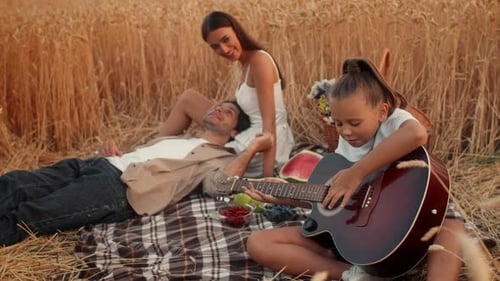 Family Enjoying Quality Time in a Wheat Field While Playing Music Together