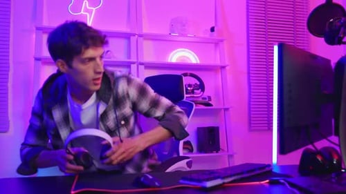 Man Puts on Headphones and Plays Computer Game