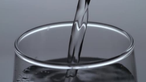 Close Up Of Drinking Water Being Poured Into A Glass On The Light White Screen Background
