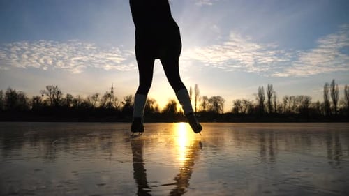 Girl Skating on Frozen River During Beautiful Sunset Young Woman Shod in Figure Skates Sliding on