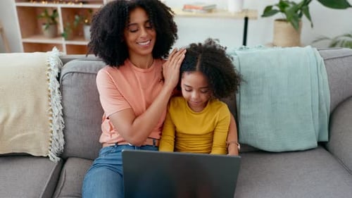 Woman and Child Enjoying Laptop Together on Couch
