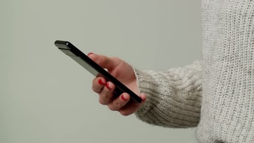 Close Up Smartphone in Caucasian Woman Hands Female Hands Typing Mobile Phone Isolated on Gray Color