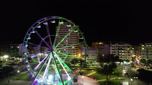 Illuminated Ferris Wheel in the City at Night