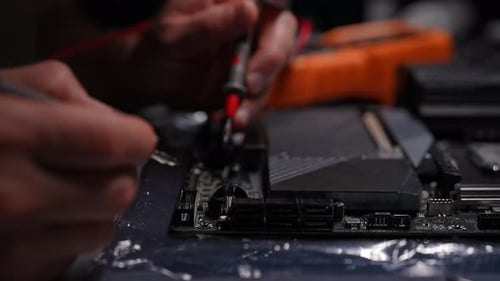 Ingeniero Electrónico Profesional que utiliza un multímetro para medir el voltaje en la placa base de la computadora durante