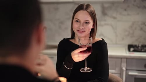 Romantisches Paar genießt Wein am Valentinstag zum Abendessen in der gemütlichen Küche