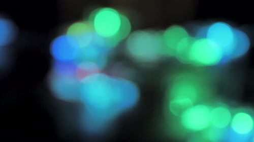 Defocused Lights Changing Colors on Black Background