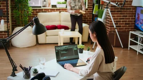 Software Developer Types Programming Code in a Cozy Home Office Setup