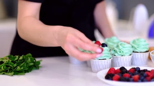 Dessert Cook Female Hand Decorates Tasty Cupcakes Turquoise Cream Topping with Raspberries and
