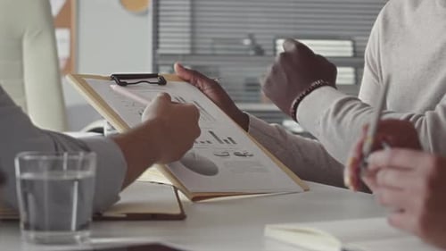 Business People Discussing Charts in Office Meeting