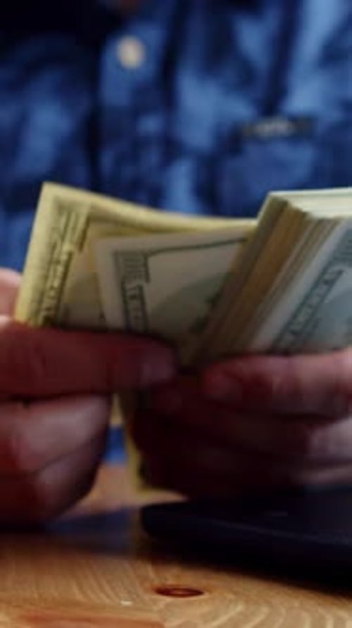 Hands Counting Stack of United States Hundred Dollar Bills