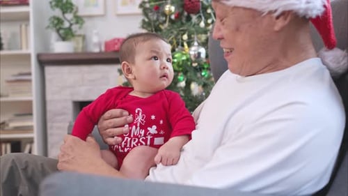Senior Adult Holding Baby at Christmas Time