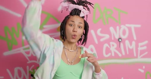 Smiling Woman Dances Against Graffiti Wall Background