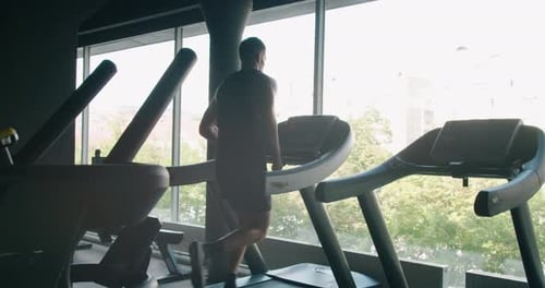 Athletic Man Run on Treadmill at Modern Gym