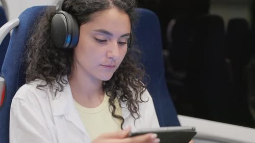 Girl Commuter Listening to Music During the Train Trip
