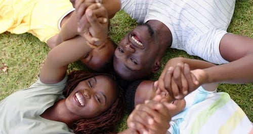 Happy Family Lying in Circle on Green Grass