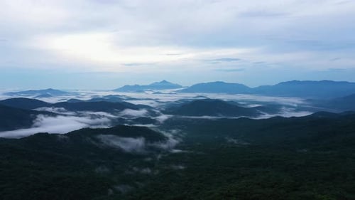 Drone shot of a beautiful scenery of the high mountains on the cloud at sunrise