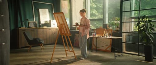 Young Woman Artist Stand Painting Picture on Canvas Hold Brush and Palette in Art Studio Workspace