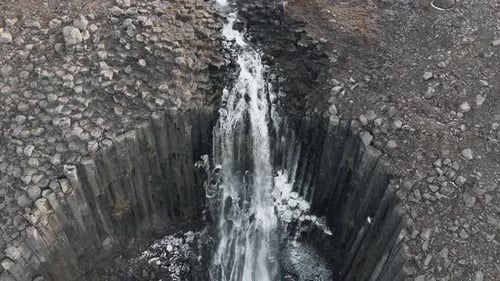 Aerial View of Waterfall Through Basalt Columns