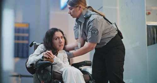 Security Checkpoint Female TSA Officer Checking Woman with Physical Disability in Airport Terminal