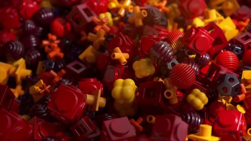 3D-abstrakter Hintergrund mit bunten geometrischen Plastikformen in Rot und Gelb Chaotisch und lebendig