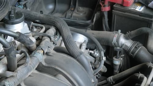 Working on Car Engine with Tool Close Up