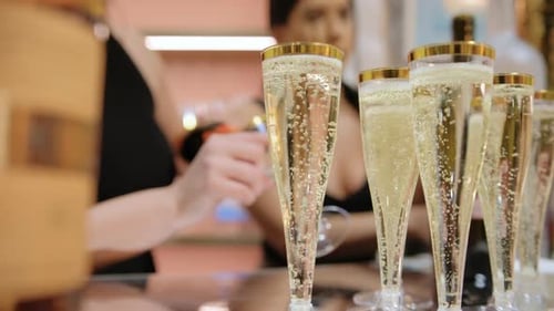 Champagne Glasses with Champagne and Bubbles at a Table on Event Close Up Footage