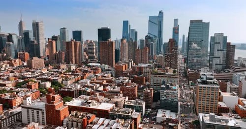Usual building contrasting with gorgeous skyscrapers. Drone flight above New York on sunny day.