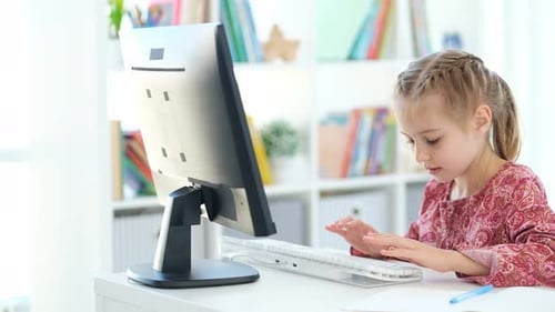 Cute Little Girl Doing Homework At Computer