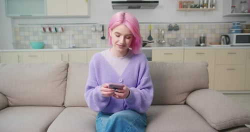 Woman with Pink Hair Using Smartphone in Kitchen