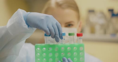 Scientist Handling Test Tubes in Laboratory Setting